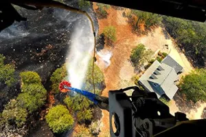 The Bambi Bucket attached to a CH-47 Chinook helicopter dumps water on a wildfire in Texas Poster Print by Stocktrek Images (17 x 11)